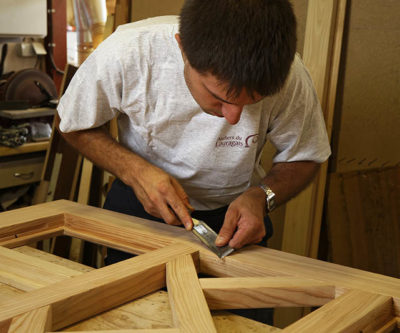Photographie de l'encart "Notre esprit" montrant un ébéniste travaillant le bois.